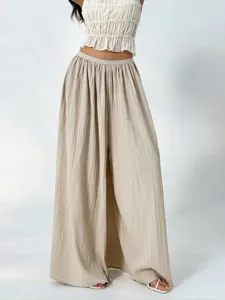 Detail view of pleated wide-leg pants featuring high waist and lightweight texture.