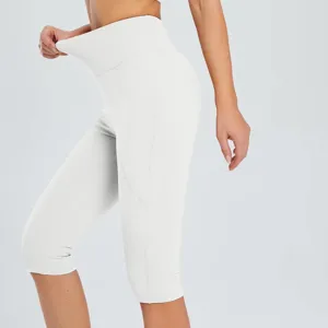 Detail view of women high waist white capri yoga pants with side pocket, stretchy gym leggings.