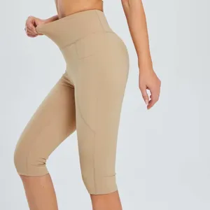High-waist side pocket capri yoga pants with stretchable breathable fabric for fitness.