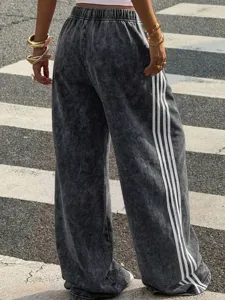 Womens vintage grey acid wash loose wide leg sweatpants with sporty side stripes for autumn.