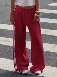 Red loose wide-leg sweatpants detail with white side stripes and casual street style.