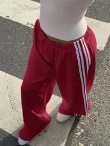 Women's casual loose wide-leg track pants with white side stripes, streetwear style.
