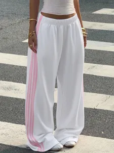 Detail shot of women's casual loose wide-leg sweatpants in white with pink side stripes.