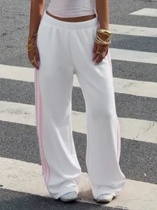Women casual loose sweatpants detail showing white knit wide-leg pants with pink stripes.