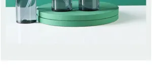 Detail view of dark translucent travel spray bottles placed on a green display platform stand.