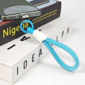 Detailed view of blue woven phone lanyard wrist strap with metal ring and clear tether tab.