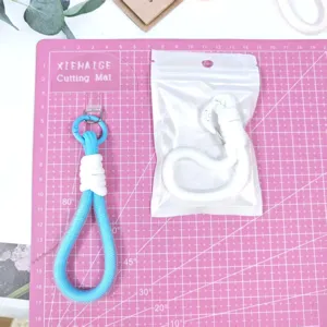 Detailed view of woven phone lanyard strap key chain in blue and white colors with packaging.