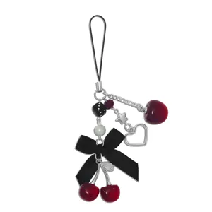 Zoet-stoere kers telefoonhanger detail met zwarte strik, ster en hart voor tassen of bekers.