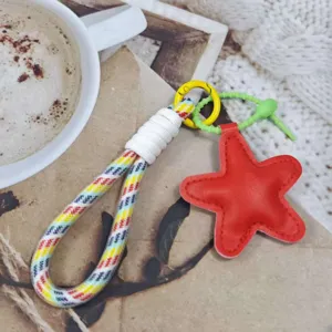 Close-up of colorful braided phone strap with red star pendant and keychain ring for daily use