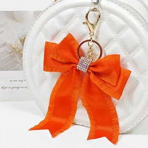 Orange ribbon bow keychain with sparkling rhinestones bag charm detailed shot for elegant style
