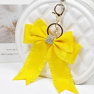 Yellow fabric bow keychain with sparkling rhinestones, perfect cute bag charm and accessory.