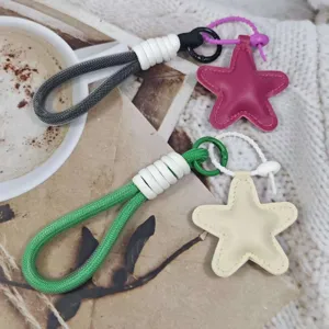 Detailed shot of colorful braided phone lanyards and leather star keychains in lifestyle setting.
