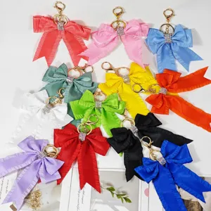 Colorful ribbon bow keychain with sparkling rhinestone ring, stylish bag charm pendant.