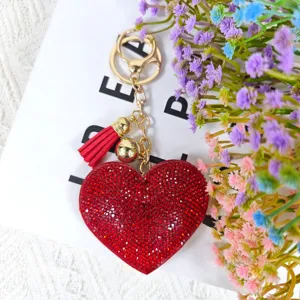 Porte-clés cœur en strass rouge avec quincaillerie dorée et pompon chic pour sacs.