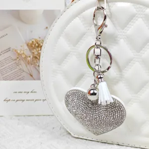Porte-clés cœur en strass scintillant avec pompon blanc et fermoir métallique pour sacs à main.
