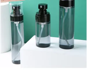 Detail view of empty refillable spray bottles for travel, showing fine mist pump mechanism.