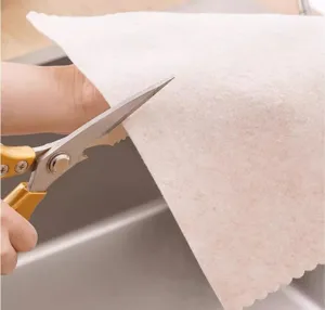 Close-up detail shot showing hands cutting a soft absorbent microfiber cleaning dishcloth easily.