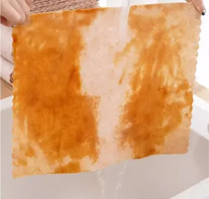 Detailed view of the absorbent cleaning dish cloth being rinsed with water in a clean kitchen sink.
