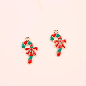 Detailed view of Christmas candy cane alloy charms with red enamel bows for DIY jewelry making.