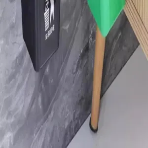 Primo piano dettaglio di pattumiera a parete con logo di riciclo su parete grigia.