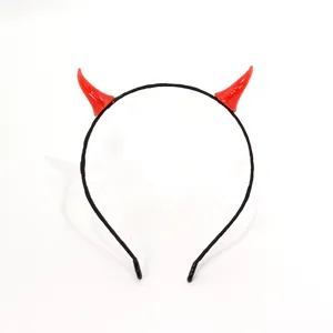 Detalle de la diadema de cuernos de diablo rojos con cuernos brillantes en banda negra.