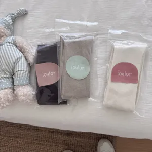Detailed view of IOULOR wool over-the-knee long socks in three neutral colors.
