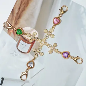 Gold alloy cross charm with colorful heart rhinestones and pearl details for DIY bag pendants.