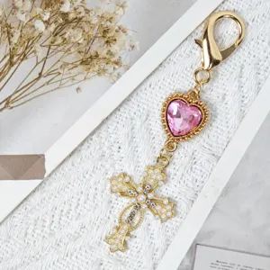 Gold alloy pink rhinestone heart cross keychain bag charm with elegant pearl design details.