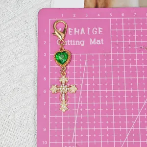 Alloy cross keychain with green heart crystal and pearls, perfect for DIY bag charm and accessories.
