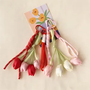 Detailed view of handmade woven tulip bag charm keychain, exquisite floral strap accessory.
