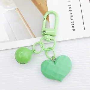 Vue détaillée de porte-clés cœur facetté vert, joli pendentif clochette pour sac et écouteurs.