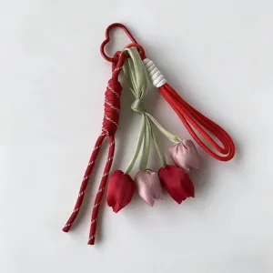 Tulip keychain detail view, featuring red braided cord and charming fabric flower pendants.