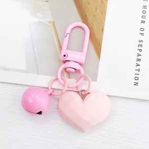Détail de porte-clés cœur facetté rose, joli pendentif cloche pour sac et décoration d'écouteur.