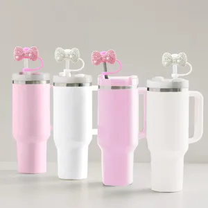 Close-up details of the stainless steel tumbler featuring a shiny rhinestone bow straw cover.