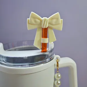 Silicone bow straw topper detail closeup for 10mm tumblers, cute white dust plug and pearl charm.