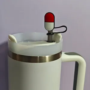 Detailed close-up of a cute medical capsule straw cover on a white stainless steel tumbler.