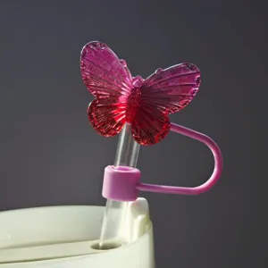 Primo piano dettagliato di un topper per cannuccia a farfalla in cristallo rosa per tazze.