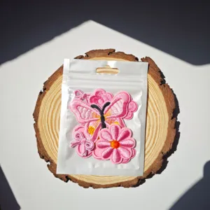 Set di toppe ricamate con farfalla e fiore rosa, vista dettagliata accessori per abbigliamento.