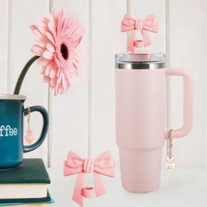 Pink tumbler detail view featuring silicone bow straw topper and cute letter M heart charm.