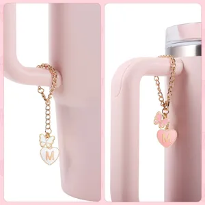 Detailed close-up of a pink tumbler handle chain pendant with a cute heart letter M and butterfly.