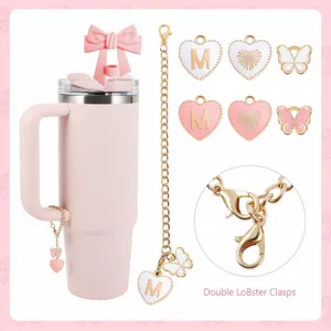 Pink tumbler with bow straw cover, letter M heart and butterfly charm accessories set.