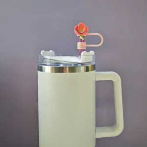 Detailed view of a white insulated tumbler with a cute pink cherry blossom straw topper.