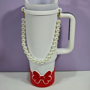 Vue détaillée du gobelet blanc avec sangle en perles élégante et housse en silicone nœud rouge.