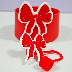 Détail de l'accessoire de manchon de tasse et couvre-paille en silicone nœud rouge.