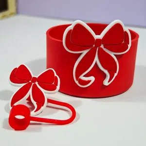 Ensemble de manchon de tasse en silicone et bouchon de paille nœud rouge détail.