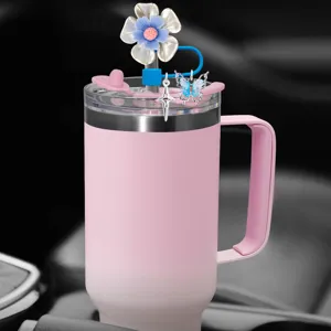 Detail shot of pink tumbler with cute flower straw cover and butterfly charms for car cup holder.