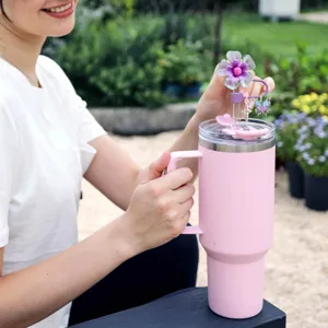 Pink insulated tumbler with purple flower straw cover and cute butterfly star charms detail.