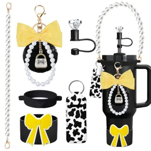 Detailed view of Stanley tumbler accessories set including pearl strap, bow keychain and straw topper.