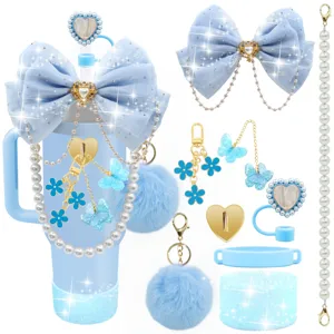 Vista dettagliata del set accessori tazza blu con fiocco, ciondoli, pon-pon e copricanna.