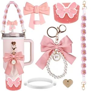 Detailed view of pink insulated tumbler accessories set with cute bows, pearl keychains and straps.
